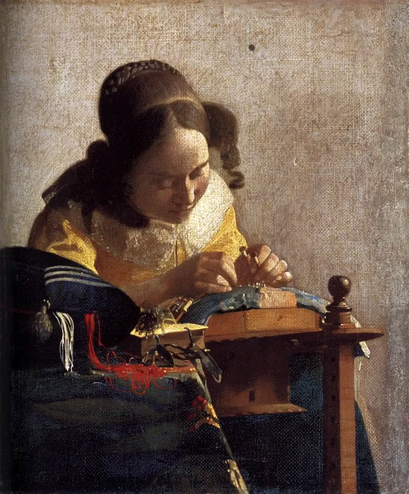 A young woman in a yellow jacket bends close over her lace pillow, working fine threads with bobbins and pins.